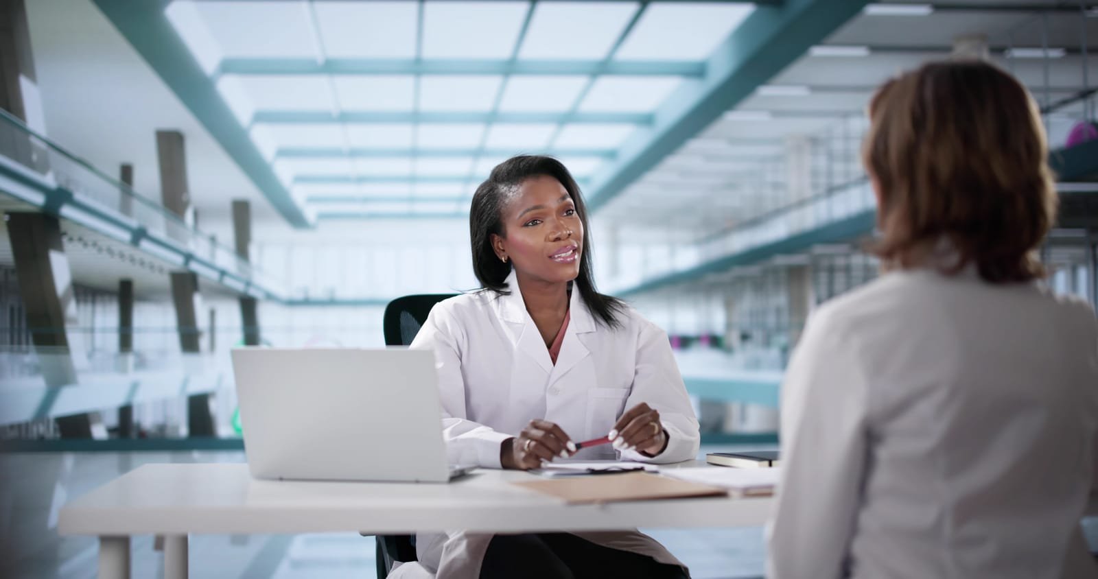95065350_unhappy-doctor-sits-in-a-disciplinary-meeting-with-black-office-backdrop
